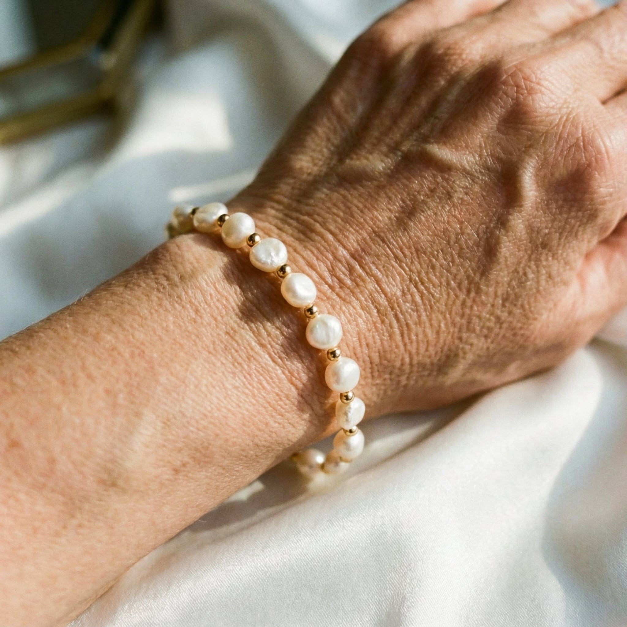Bracciale bianco retrò con perle e dettagli dorati