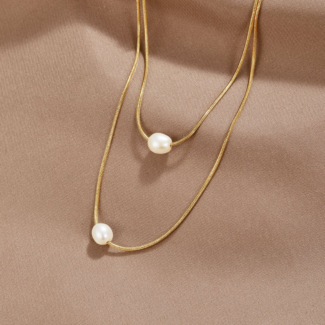 Sabina – Collana d'oro a due strati con pietra scura.