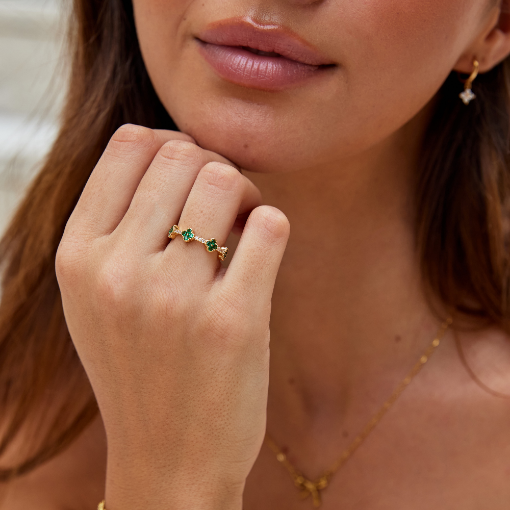 Annika – Anello d'oro con dettagli floreali e elemento in smeraldo.